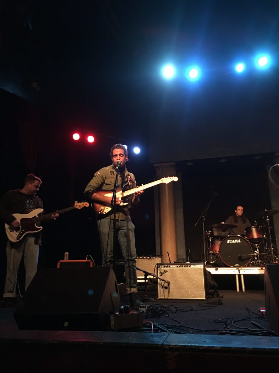 man on stage with guitar